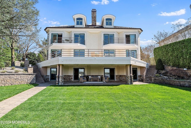 view of front of house with a balcony, a patio, and a front yard