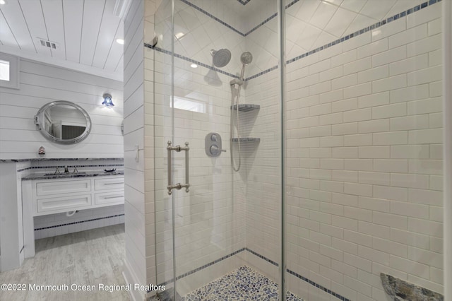 bathroom with hardwood / wood-style floors, vanity, and walk in shower