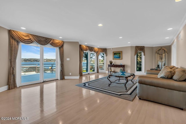 living room with light wood-type flooring, a water view, and ornamental molding