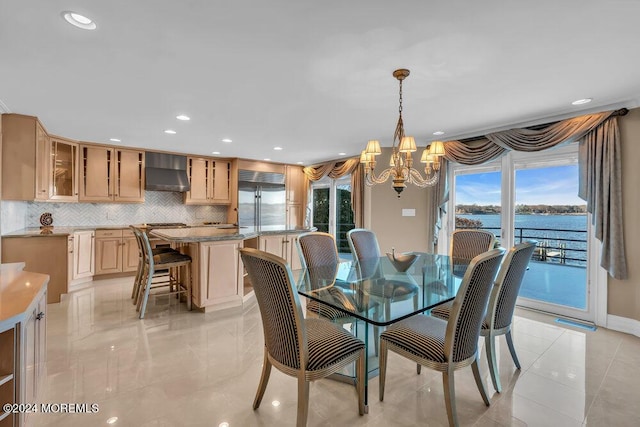 dining space with a water view and an inviting chandelier