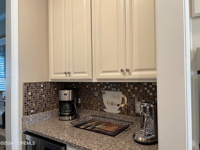 kitchen with white cabinets, backsplash, and dark stone countertops