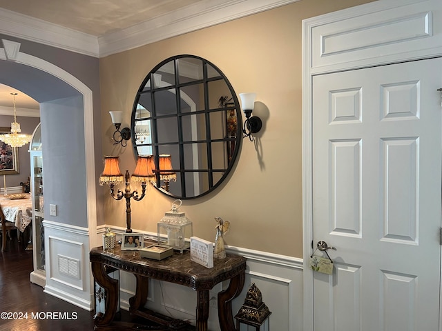 interior details featuring hardwood / wood-style flooring, ornamental molding, and an inviting chandelier