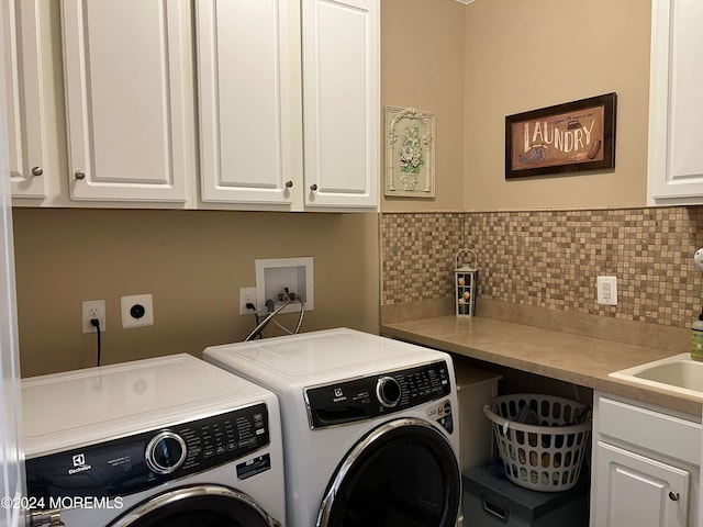 clothes washing area featuring cabinets and washing machine and clothes dryer