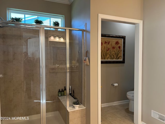 bathroom featuring tile patterned floors, a shower with door, and toilet