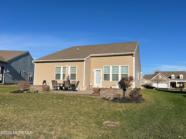 rear view of house with a yard and a patio