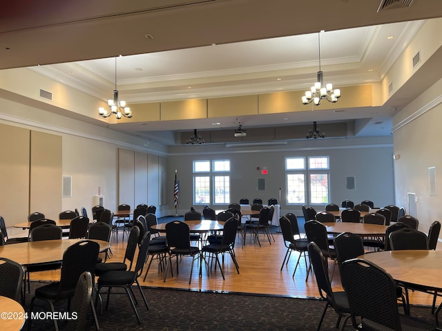 dining space featuring a chandelier, hardwood / wood-style floors, a raised ceiling, and crown molding