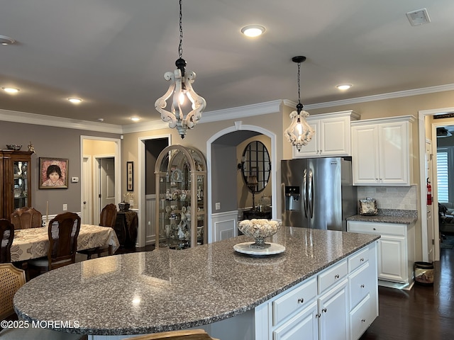 kitchen featuring stainless steel fridge with ice dispenser, a center island, white cabinets, and dark stone counters