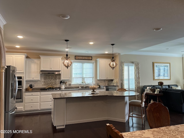 kitchen featuring dark stone countertops, sink, white cabinets, and pendant lighting