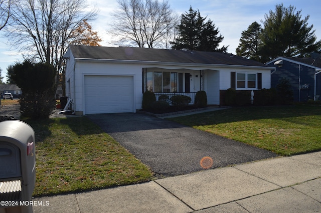 single story home featuring a front lawn, covered porch, and a garage