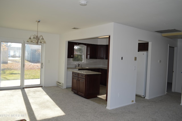 kitchen featuring backsplash, white appliances, light colored carpet, decorative light fixtures, and an inviting chandelier