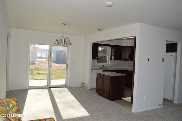 kitchen featuring a notable chandelier, white fridge, light colored carpet, and decorative light fixtures