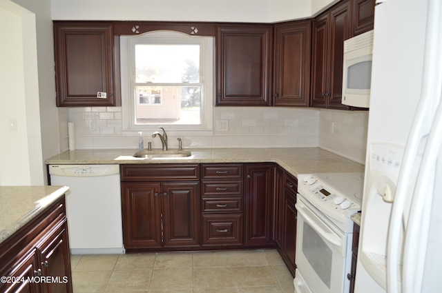 kitchen featuring decorative backsplash, sink, light stone countertops, and white appliances