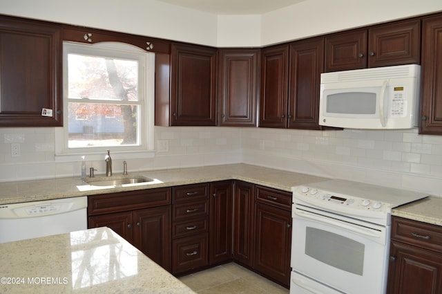 kitchen with white appliances, backsplash, sink, light stone countertops, and light tile patterned floors