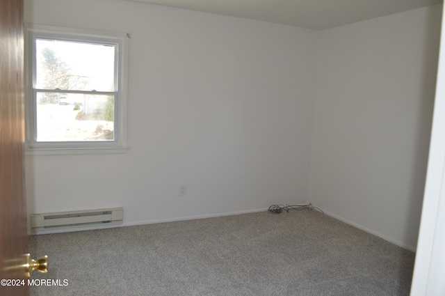 carpeted empty room with a baseboard radiator