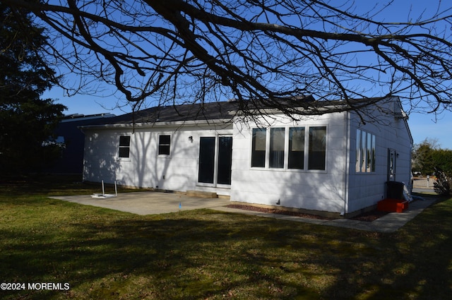 back of property with a yard and a patio area