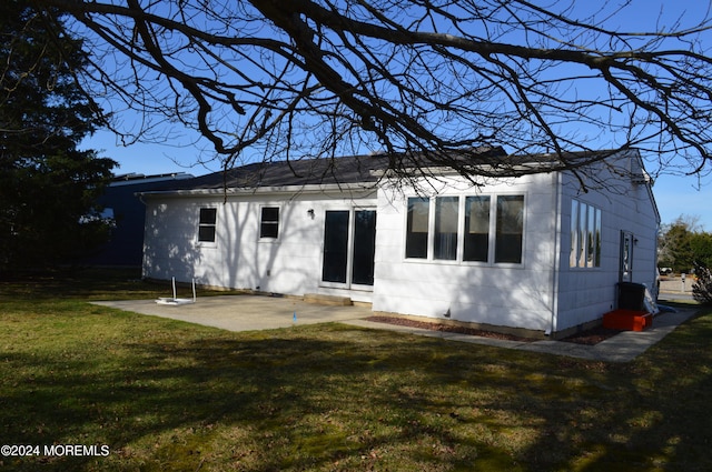 back of house with a yard and a patio