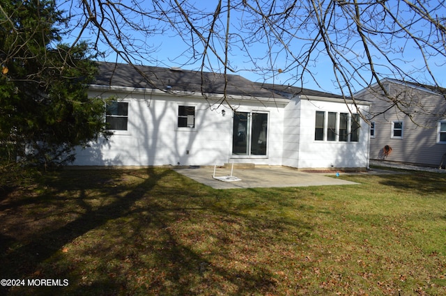 back of property featuring a lawn and a patio