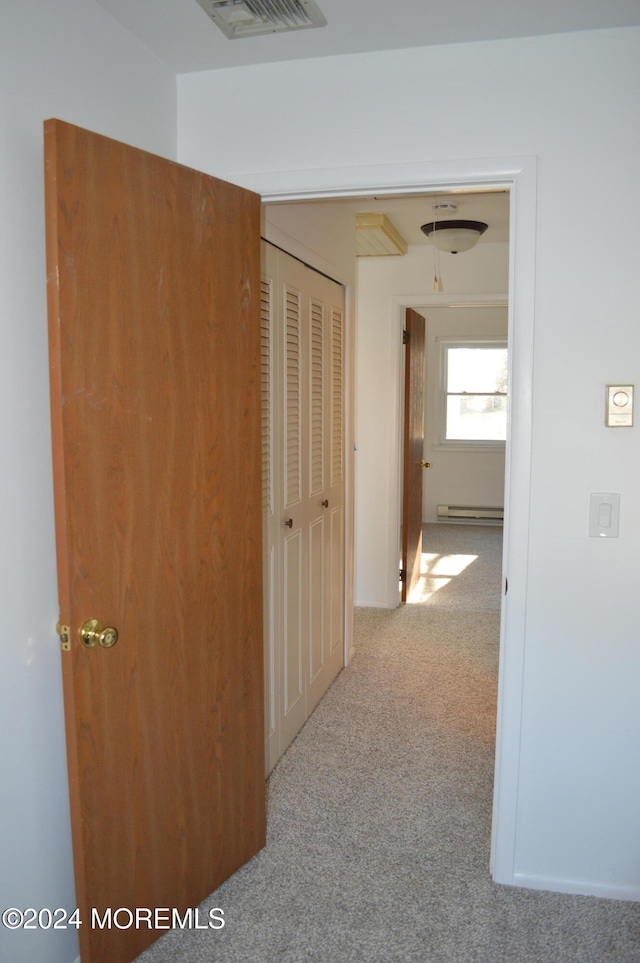 hallway featuring light carpet and a baseboard radiator