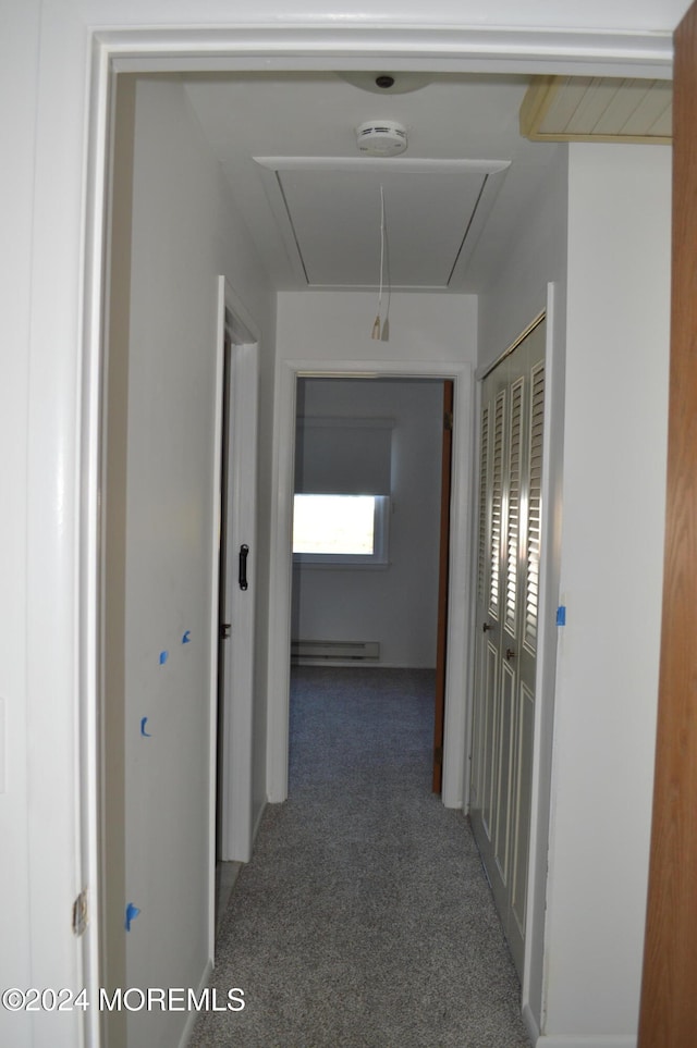 hallway featuring dark carpet and a baseboard heating unit