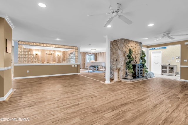 unfurnished living room with ceiling fan with notable chandelier and wood-type flooring