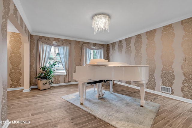 misc room with a chandelier, light hardwood / wood-style floors, and ornamental molding