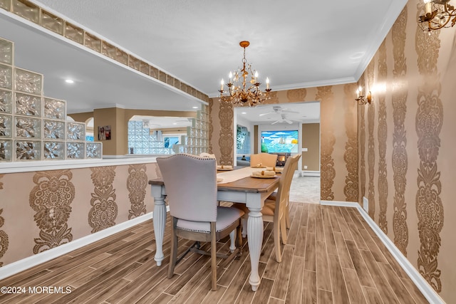 dining space featuring wood-type flooring, crown molding, a baseboard radiator, and an inviting chandelier