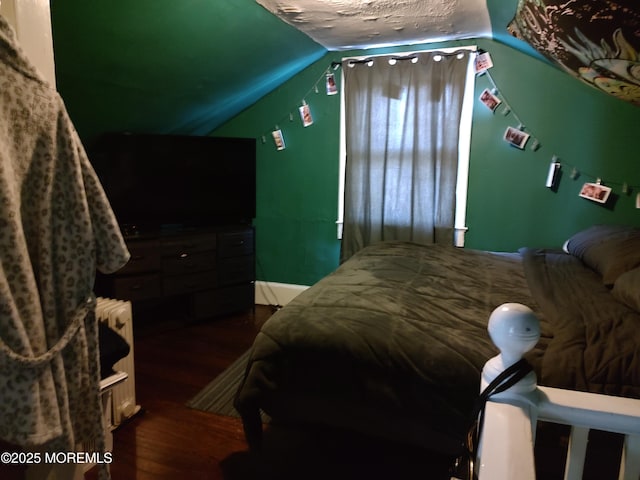 bedroom featuring lofted ceiling, dark wood-type flooring, and a textured ceiling