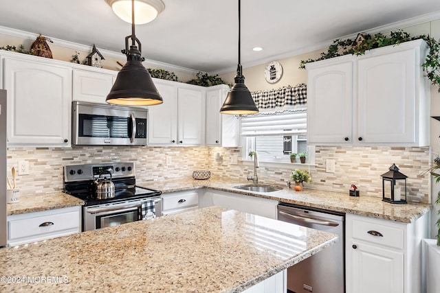 kitchen featuring sink, white cabinets, stainless steel appliances, and decorative light fixtures