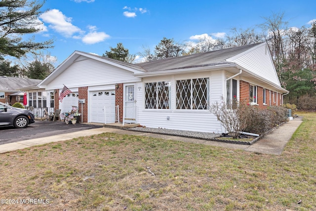 ranch-style house featuring a garage and a front yard