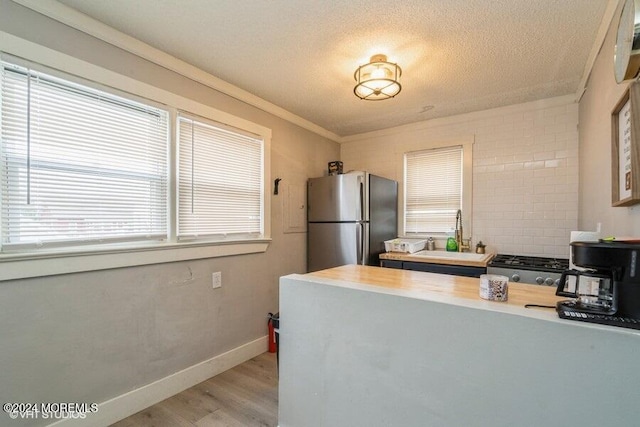 kitchen featuring sink, stainless steel appliances, plenty of natural light, and light hardwood / wood-style floors