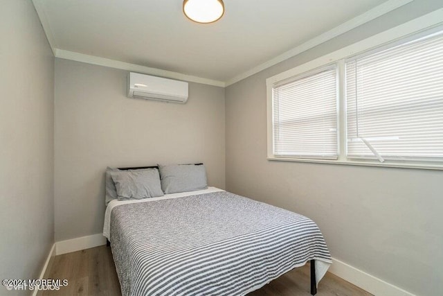 bedroom with ornamental molding, a wall mounted air conditioner, and hardwood / wood-style flooring