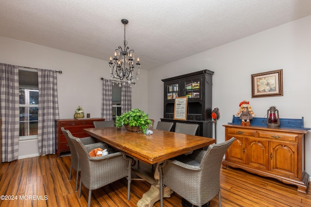 dining room with a chandelier, a textured ceiling, and hardwood / wood-style flooring