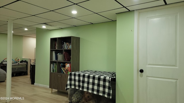 corridor featuring a drop ceiling and light hardwood / wood-style floors