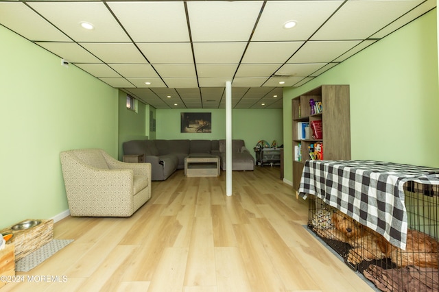 bedroom with light wood-type flooring and a paneled ceiling