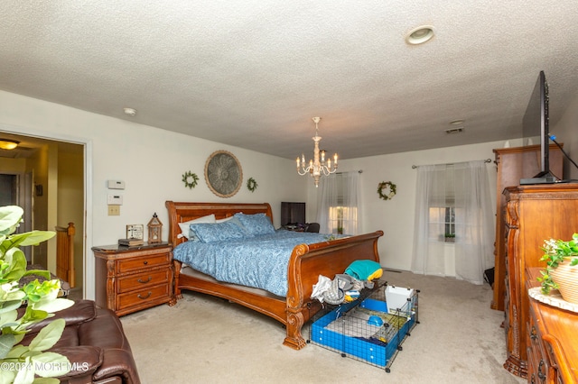 bedroom with a chandelier, a textured ceiling, and light colored carpet