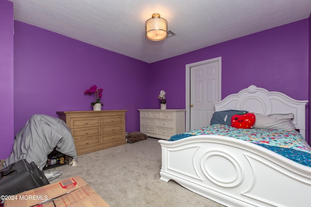 bedroom with light carpet and a textured ceiling