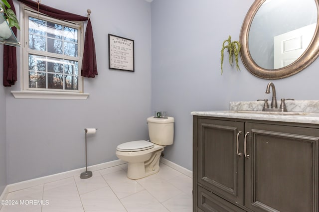 bathroom with tile patterned flooring, vanity, and toilet