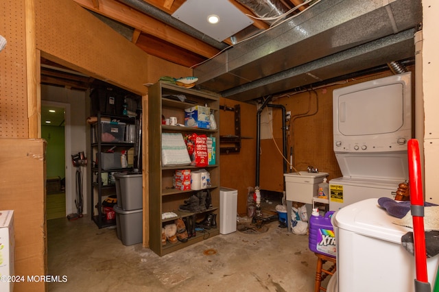 basement with stacked washer / drying machine