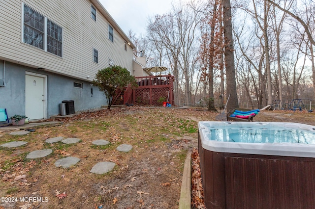 view of yard with a hot tub and a wooden deck