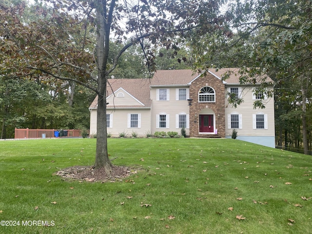 colonial home featuring a front lawn