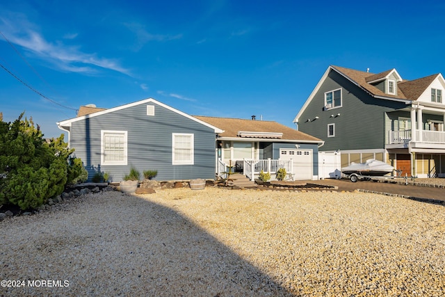 back of house with a porch and a garage