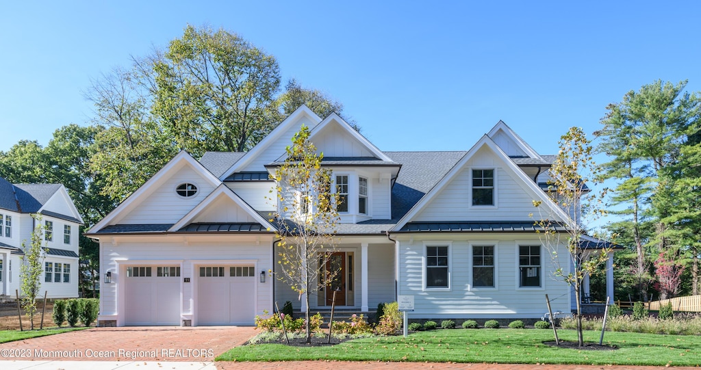 3 Bingham Ct, Rumson, NJ 07760 - view of front of house featuring a standing seam roof, decorative driveway, a front lawn, metal roof, and roof with shingles