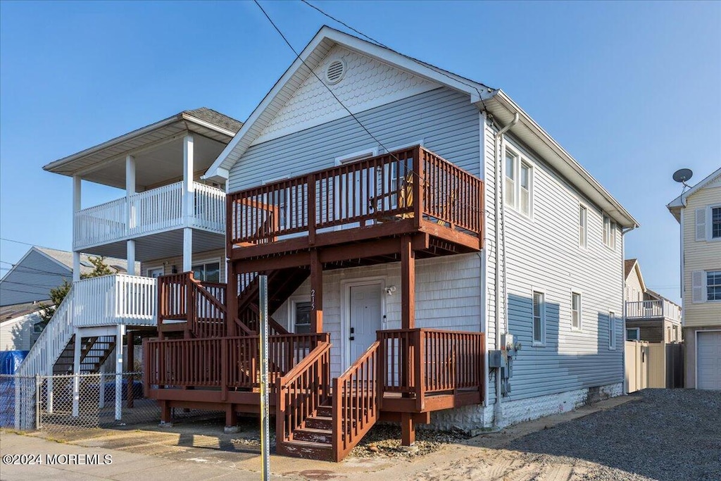 rear view of house featuring a wooden deck