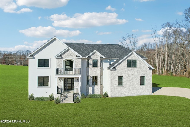 view of front of property featuring a balcony and a front lawn