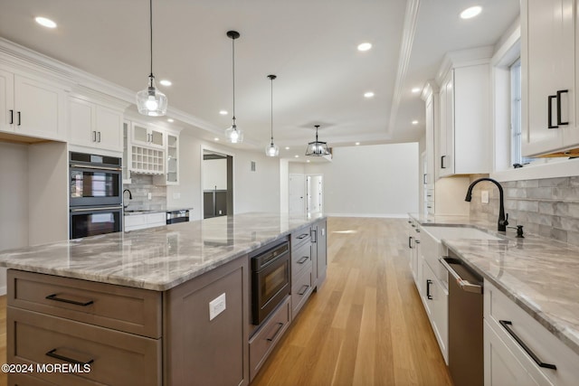 kitchen with white cabinets, appliances with stainless steel finishes, and hanging light fixtures