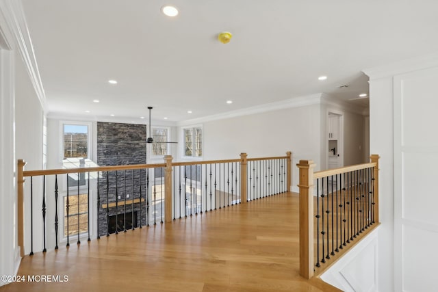 hall with light hardwood / wood-style flooring and ornamental molding