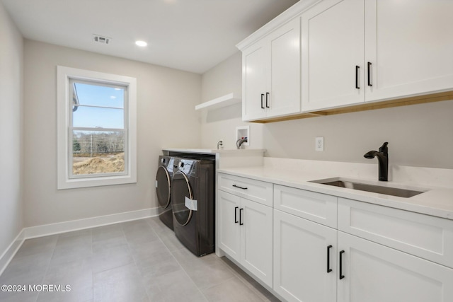 laundry area with washer and dryer, sink, light tile patterned floors, and cabinets