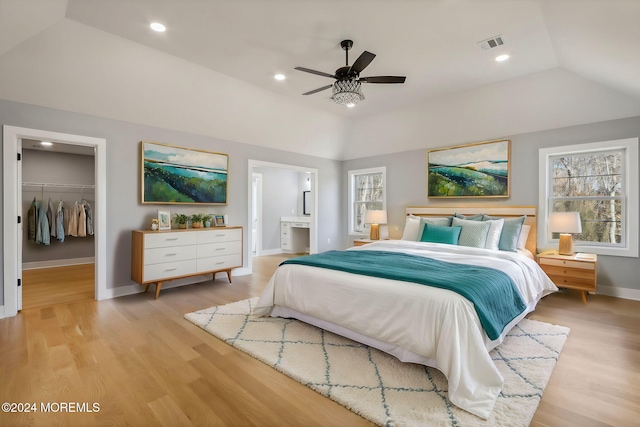 bedroom featuring ceiling fan, a spacious closet, light hardwood / wood-style floors, a closet, and lofted ceiling