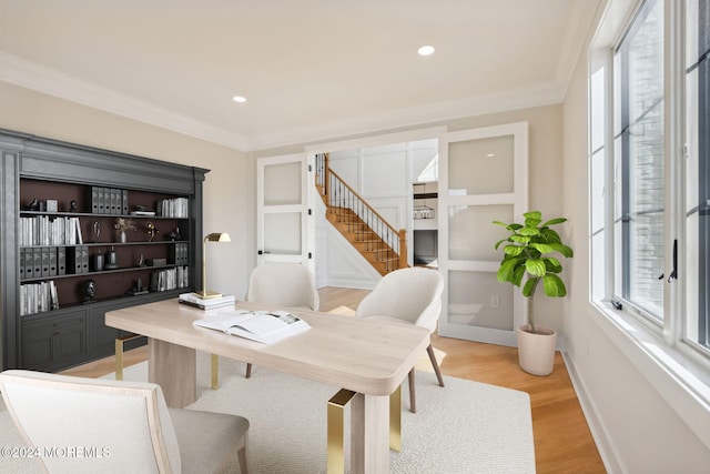 office with light hardwood / wood-style floors and crown molding