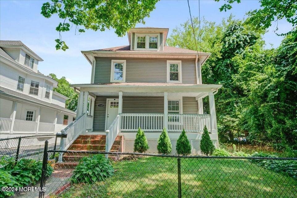 view of front of house with covered porch and a front lawn